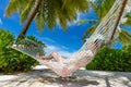 Woman lying on hammock between palms on a tropical beach. Maldives Royalty Free Stock Photo