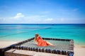 Woman lying on hammock on tropical beach, enjoying turquoise water and blue sky Royalty Free Stock Photo