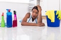 Woman Lying On Kitchen Floor Looking At Cleaning Products Royalty Free Stock Photo