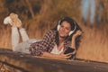 Woman lying on lake docks listening to the music