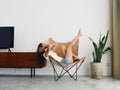 Woman lying in a leather armchair raised arms and legs cheerful happiness and a smile, relaxing at home stylish modern Royalty Free Stock Photo