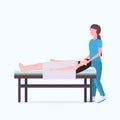 Woman lying on massage bed african american masseuse therapist doing healing treatment massaging injured patient manual Royalty Free Stock Photo