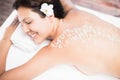 Woman lying on massage table with salt scrub on back Royalty Free Stock Photo