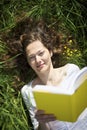 Woman lying in meadow reading Royalty Free Stock Photo