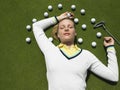 Woman Lying On Putting Green With Golf Balls