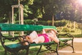 Woman lying and resting on green bench in the park Royalty Free Stock Photo