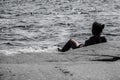 Woman lying on a rock in the ocean looking out at the horizon Royalty Free Stock Photo