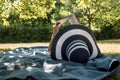 Woman lying on a rug in the shade of a tree reading a book Royalty Free Stock Photo