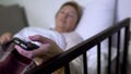 Woman lying on sickbed and switching channels on tv, personal ward in hospital