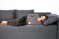 Woman lying on sofa looking sick