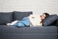 Woman lying on sofa looking sick in the living room