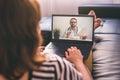 Woman lying on a sofa and talking with a doctor online using laptop. Telemedicine concept. Royalty Free Stock Photo