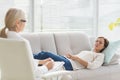 Woman lying on sofa while talking to therapist Royalty Free Stock Photo