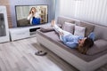 Woman Lying On Sofa Watching Television Royalty Free Stock Photo