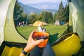 Woman lying in a tent with coffee ,view of camping Royalty Free Stock Photo