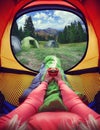 Woman lying in a tent with coffee ,view of mountains and sky Royalty Free Stock Photo