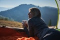 Woman lying in tent and looking mountain landscape. Royalty Free Stock Photo