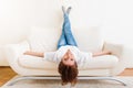 Woman lying upside down on a sofa Royalty Free Stock Photo