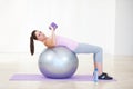 Woman, lying and workout on ball, dumbbells and balance in gym, training and strong muscle in arms. Girl, portrait and Royalty Free Stock Photo