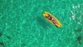 Woman lying on yellow paddle board in open sea