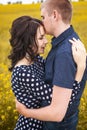 Woman and macho hugging on yellow meadow