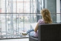 Woman With Magazine Sitting On Sofa In Shopping Mall Royalty Free Stock Photo