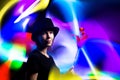 Woman magician in a black hat against a background of multi-colored light. Magic, sorcery, horoscope concept Royalty Free Stock Photo