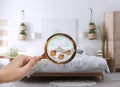 Woman with magnifying glass detecting bed bugs in bedroom Royalty Free Stock Photo