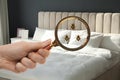 Woman with magnifying glass detecting bed bugs in bedroom, closeup Royalty Free Stock Photo