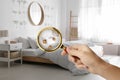 Woman with magnifying glass detecting bed bugs in bedroom Royalty Free Stock Photo