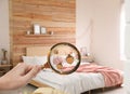 Woman with magnifying glass detecting bed bugs in bedroom Royalty Free Stock Photo