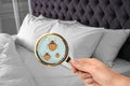 Woman with magnifying glass detecting bed bugs Royalty Free Stock Photo