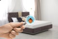 Woman with magnifying glass detecting bed bugs on mattress