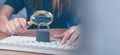 Woman magnifying glass looking at keyboard with lock