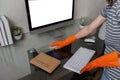 Woman housekeeper cleaning and wiping desk with microfiber cloth at home office Royalty Free Stock Photo