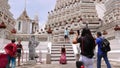 Woman make pictures on staps of famous Wat Arun temple at Bangkok