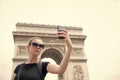 Woman make selfie with phone at arc de triomphe in paris, france. Woman with smartphone at arch monument. Vacation and Royalty Free Stock Photo