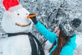 Woman make a snowman in frosty winter day Royalty Free Stock Photo