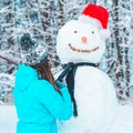 Woman make a snowman in frosty winter day Royalty Free Stock Photo