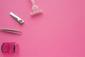 Woman make up equipment - tweezers, plastic eyelash curler and nail clippers on pink background. Copy space for text