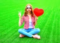 woman makes an air kiss with red balloon in the shape of a heart Royalty Free Stock Photo