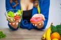 Woman makes a choice between harmful and healthy foods Royalty Free Stock Photo