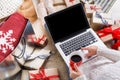 Woman makes christmas shopping online with laptop, above view
