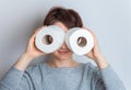 Woman makes glasses from rolls of toilet paper. Excitement, panic, devastation of shops. Studio photo, 