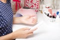 A woman makes her own manicure. Removes old nail Polish with a nail buff. Taken in close-up
