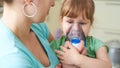 Woman makes inhalation to a child at home. brings the nebulizer mask to his face. inhales the vapor of the medication. the girl Royalty Free Stock Photo