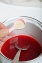 A woman makes jelly from raspberry syrup. Adds a spoonful of agar agar. Levington cake, stages of preparation Royalty Free Stock Photo