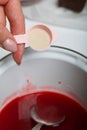 A woman makes jelly from raspberry syrup. Adds a spoonful of agar agar. Levington cake, stages of preparation Royalty Free Stock Photo