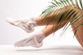 A woman makes a mask on the feet against dryness, cracked skin on the heels and against fatigue with a spa salon Royalty Free Stock Photo