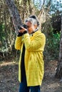 Woman makes photos with analog reflex camera in the forest
